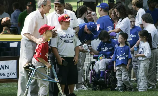 FILE - President George W. Bush, left, and National Baseball Hall of Fame member Willie Mays, back right, pose with Robert Shaffer and Colin Schildt, of Challengers from Thurmont Little League and Civitan Club of Frederick in Thurmont , Md., during a ceremony at the conclusion of the White House Tee Ball Game on the South Lawn, Sunday, July 30, 2006, in Washington. (AP Photo/Manuel Balce Ceneta, File)