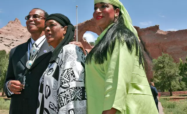 FILE - Nation of Islam leader Louis Farrakhan, his wife Khadijah Farrakhan, and their daughter, Maria Farrakhan Mohammad, pose for photographers in front of the Window Rock Navajo Monument, Wednesday, July 19, 2006, in Window Rock, Ariz. (AP Photo/Matt York, File)
