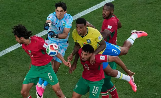 Morocco goalkeeper Yassine Bounou (1) punches the ball away from Brazil's Gabriel Magalhaes (3) as Morocco's Ayyoub Bouaddi (6), Chadi Riad (18) and Issa Diop get in on the play during the World Cup Group C soccer match in East Rutherford, N.J., near New York, Saturday, June 13, 2026. (AP Photo/Matt Slocum)