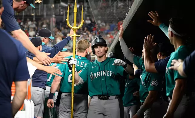 Seattle Mariners' Colt Emerson celebrates his two-run home run in the dugout during the second inning of a baseball game against the Washington Nationals, Friday, June 12, 2026, in Washington. (AP Photo/Nick Wass)