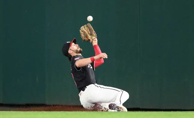 Washington Nationals right fielder Dylan Crews makes a sliding catch on a sacrifice fly by Seattle Mariners' Miles Mastrobuoni during the second inning of a baseball game, Friday, June 12, 2026, in Washington. (AP Photo/Nick Wass)