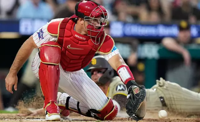 San Diego Padres' Ty France scores past Philadelphia Phillies' J.T. Realmuto on a run-scoring single by San Diego Padres' Jackson Merrill during the seventh inning of a baseball game Wednesday, June 3, 2026, in Philadelphia. (AP Photo/Matt Slocum)