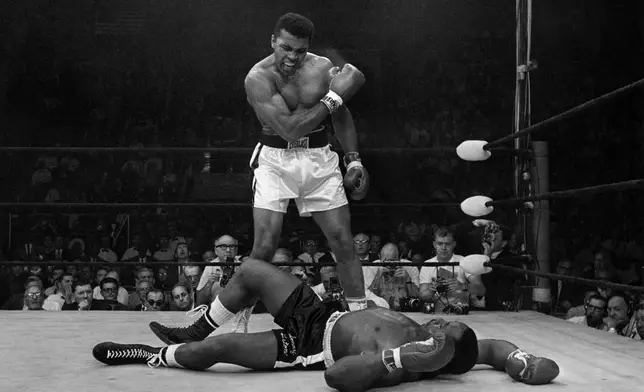 FILE - Heavyweight champion Muhammad Ali stands over fallen challenger Sonny Liston, shouting and gesturing shortly after dropping Liston with a short hard right to the jaw on May 25, 1965, in Lewiston, Maine. (AP Photo/John Rooney, file)