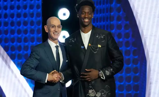 AJ Dybantsa, right, poses for a photo with NBA commissioner Adam Silver, left, after being selected by the Washington Wizards as the first pick in the first round of the NBA basketball draft, Tuesday, June 23, 2026, in New York. (AP Photo/Yuki Iwamura)