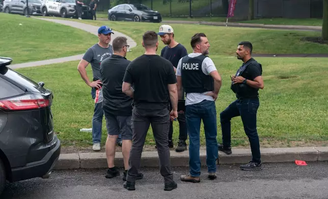 Investigators work the scene where a Toronto Police officer was shot in Toronto on Thursday, June 11, 2026. (Arlyn McAdorey/The Canadian Press via AP)