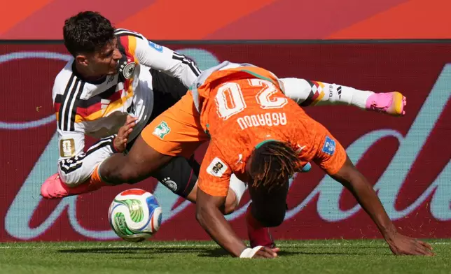 Germany's Kai Havertz, left, falls as he is tackled by Ivory Coast's Emmanuel Agbadou during the World Cup Group E soccer match between Germany and Ivory Coast in Toronto, Saturday, June 20, 2026. (AP Photo/Stephanie Scarbrough)