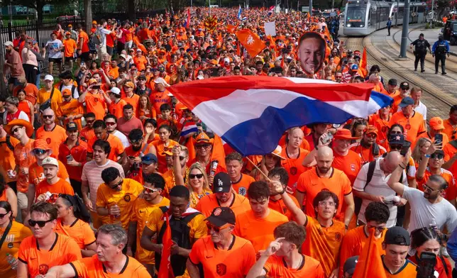 Netherlands fans take part in an "Orange Walk" to Houston Stadium before a FIFA World Cup Group F soccer match between Netherlands and Sweden in Houston, Saturday, June 20, 2026. (AP Photo/Jon Shapley)