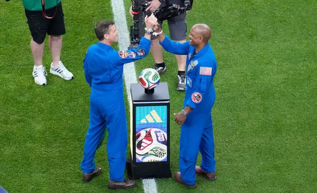 Astronauts Reid Wiseman and Victor Glover, right, ahead of the World Cup Group F soccer match between the Netherlands and Sweden in Houston, Saturday, June 20, 2026. (AP Photo/Karen Warren)