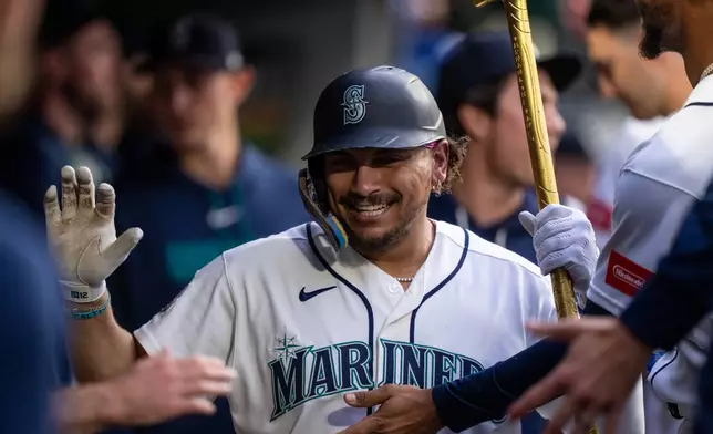 Seattle Mariners' Josh Naylor celebrates in the dugout after hitting a solo home run during the seventh inning of a baseball game against the New York Mets, Monday, June 1, 2026, in Seattle. (AP Photo/Stephen Brashear)