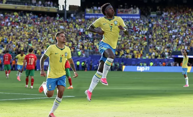 Brazil's Vinicius Junior (7) celebrates with teammate Bruno Guimaraes (8) after scoring during the World Cup Group C soccer match against Morocco in East Rutherford, N.J., near New York, Saturday, June 13, 2026. (AP Photo/Adam Hunger)