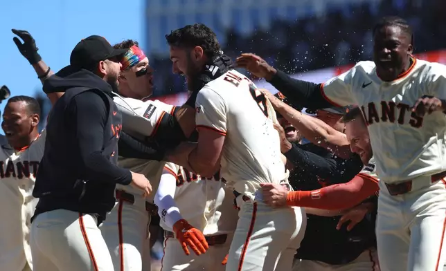 San Francisco Giants' Bryce Eldridge, center, celebrates with teammates after hitting a game winning grand slam against the Washington Nationals during the ninth inning of a baseball game in San Francisco, Wednesday, June 10, 2026. (AP Photo/Jed Jacobsohn)