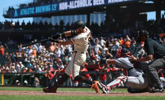 San Francisco Giants' Bryce Eldridge hits a grand slam in front of Washington Nationals catcher Keibert Ruiz during the ninth inning of a baseball game in San Francisco, Wednesday, June 10, 2026. (AP Photo/Jed Jacobsohn)