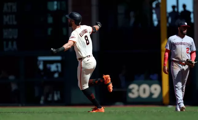 San Francisco Giants' Bryce Eldridge (8) rounds the bases after hitting a grand slam in front of Washington Nationals first baseman Luis García Jr. (2) during the ninth inning of a baseball game in San Francisco, Wednesday, June 10, 2026. (AP Photo/Jed Jacobsohn)