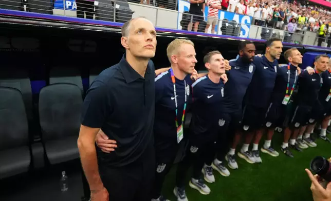 England head coach Thomas Tuchel, left, and his staff listen the national anthem prior to the World Cup Group L soccer match between England and Croatia in Arlington, Texas, near Dallas, Wednesday, June 17, 2026. (AP Photo/Julio Cortez)