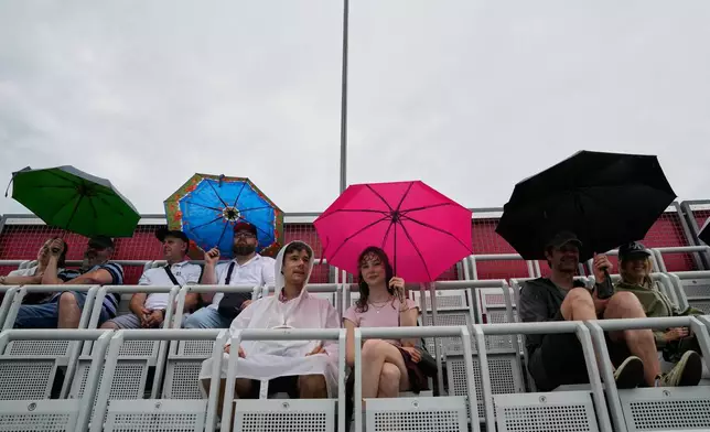 Fans wait for the start of the singles final match between United States' Jessica Pegula and Czech Republic's Linda Noskova at the WTA 500 Berlin Open tennis tournament which has been interrupted due to heavy rain in Berlin, Germany, Sunday, June 21, 2026. (AP Photo/Ebrahim Noroozi)