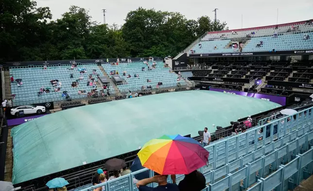 Fans wait for the start of the singles final match between United States' Jessica Pegula and Czech Republic's Linda Noskova at the WTA 500 Berlin Open tennis tournament which has been interrupted due to heavy rain in Berlin, Germany, Sunday, June 21, 2026. (AP Photo/Ebrahim Noroozi)