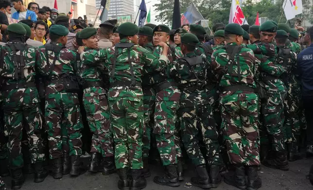 Indonesian soldiers block student protesters during a rally against a fuel price hike, government inefficient spendings, and military involvement in civilian affairs in Jakarta, Indonesia, Friday, June 12, 2026. (AP Photo/Tatan Syuflana)