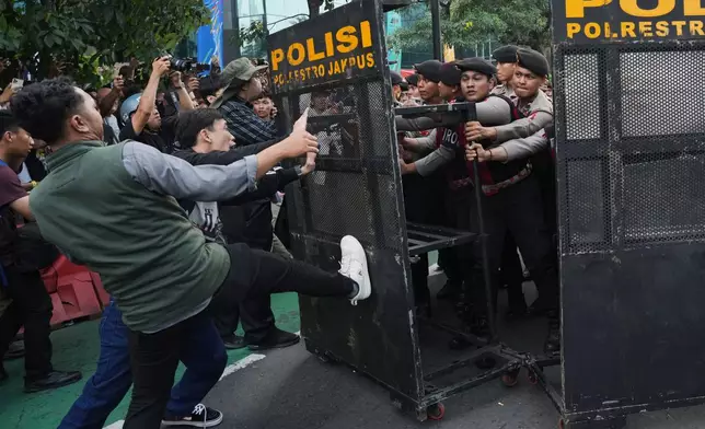 Police officers block student protesters during a rally against a fuel price hike, government inefficient spendings, and military involvement in civilian affairs in Jakarta, Indonesia, Friday, June 12, 2026. (AP Photo/Tatan Syuflana)