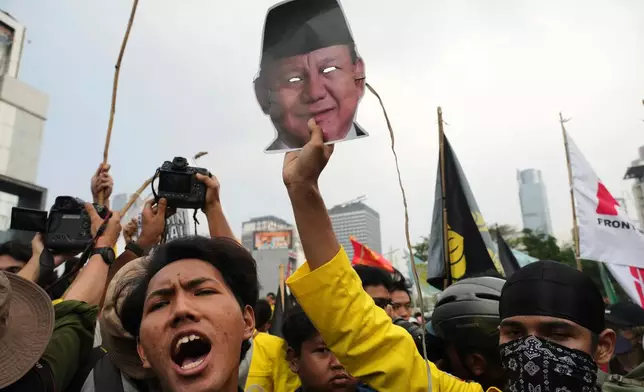 A student protester holds up a mask of Indonesian President Prabowo Subianto during a rally against a fuel price hike, government inefficient spendings, and military involvement in civilian affairs in Jakarta, Indonesia, Friday, June 12, 2026. (AP Photo/Tatan Syuflana)