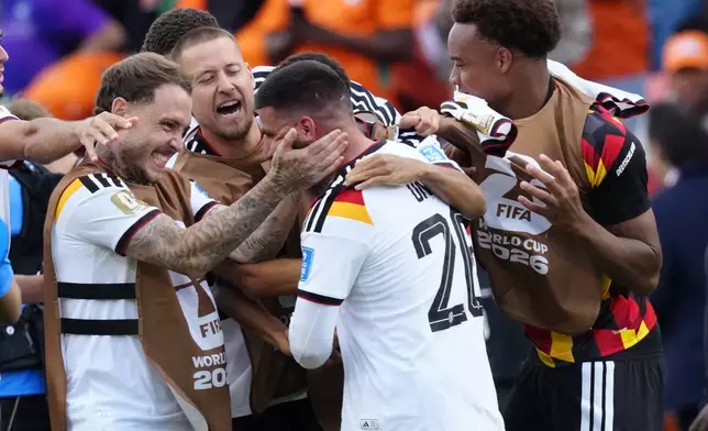 Germany's Deniz Undav (26) is mobbed by teammates after scoring their second goal during the World Cup Group E soccer match between Germany and Ivory Coast in Toronto, Saturday, June 20, 2026. (Frank Gunn/The Canadian Press via AP)