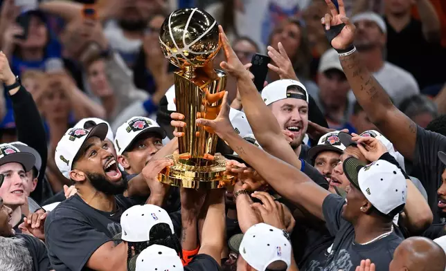 The New York Knicks celebrate with the Larry O'Brien Championship Trophy after defeating the San Antonio Spurs in Game 5 of the NBA Finals basketball series, Saturday, June 13, 2026, in San Antonio. (AP Photo/Darren Abate)