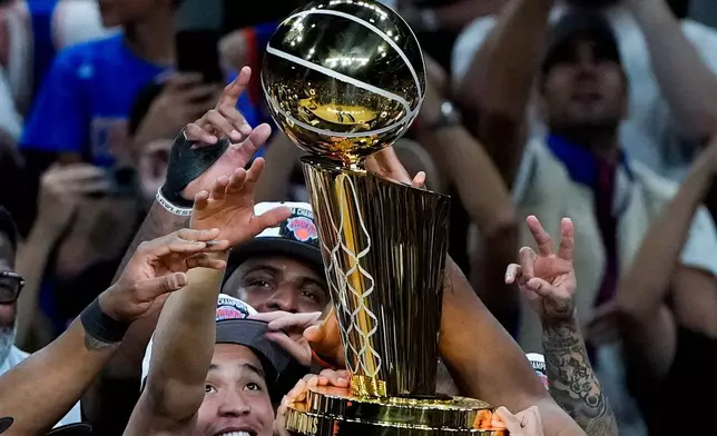 The New York Knicks celebrate with the Larry O'Brien Championship Trophy after defeating the San Antonio Spurs in Game 5 of the NBA Finals basketball series, Saturday, June 13, 2026, in San Antonio. (AP Photo/Ross D. Franklin)