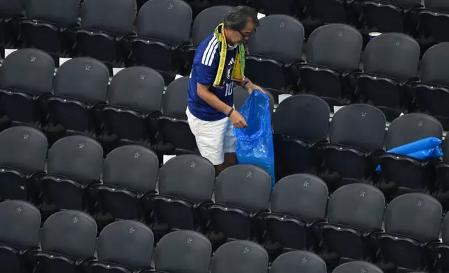 Japan fans clean up trash in the stadium following the World Cup Group F soccer match between the Netherlands and Japan in Arlington, Texas, near Dallas, Sunday, June 14, 2026. (AP Photo/Jessica Tobias)