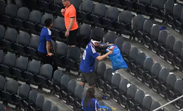 Japan fans clean up trash in the stadium following the World Cup Group F soccer match between the Netherlands and Japan in Arlington, Texas, near Dallas, Sunday, June 14, 2026. (AP Photo/Jessica Tobias)