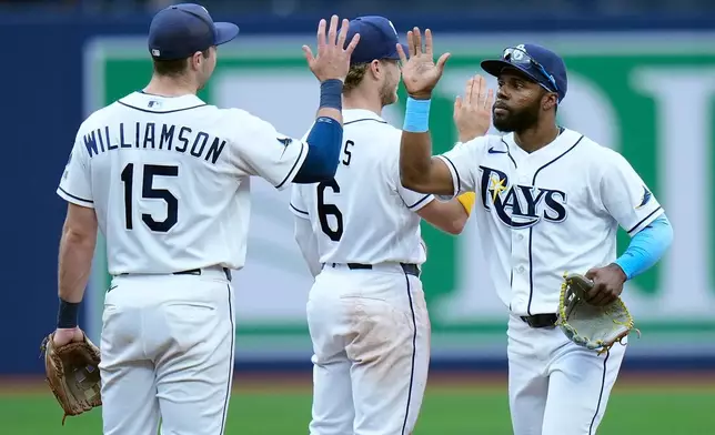 Tampa Bay Rays' Cedric Mullins celebrates with Ben Williamson (15) and Taylor Walls (6) after the team defeated the Boston Red Sox during a baseball game Wednesday, June 10, 2026, in St. Petersburg, Fla. (AP Photo/Chris O'Meara)