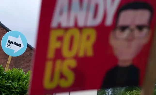 Campaign posters for Andy Burnham and for the Reform UK party are displayed in the town of Ashton-in-Makerfield before the forthcoming Makerfield by-election, in Greater Manchester, England, Tuesday, June 9, 2026. (AP Photo/Jon Super)