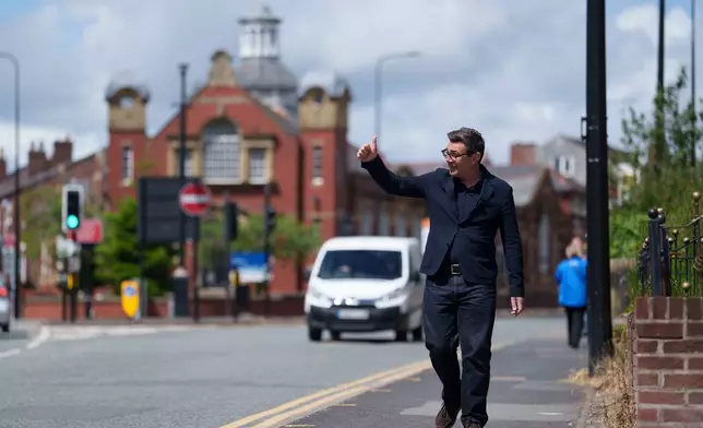 Andy Burnham gives a thumbs up to supporters during a campaign visit to Ashton-in-Makerfield before the forthcoming by-election, in Manchester, England, Tuesday, June 9, 2026. CORRECTION: corrects family name to Burnham instead of Bunham (AP Photo/Jon Super)