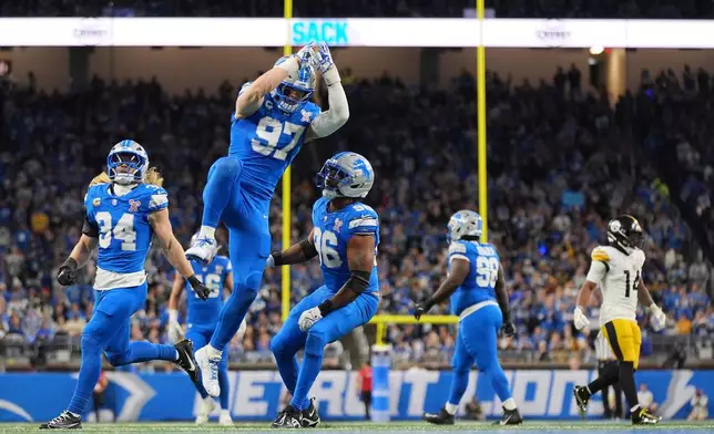 FILE - Detroit Lions' Alex Anzalone (34), Aidan Hutchinson (97) and Al-Quadin Muhammad (96) celebrate after a sack during the first half of an NFL football game against the Pittsburgh Steelers, Dec. 21, 2025, in Detroit. (AP Photo/Ryan Sun, File)