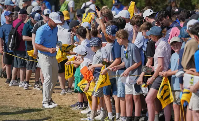 Spectators line up to get an autograph from Bryson DeChambeau of the United States, during a practice round for the British Open Golf championships at Royal Birkdale golf club, in Southport, England, Tuesday, July 14, 2026. (AP Photo/Jon Super)