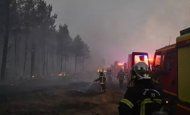 Firefighters battle a wildfire near Marcheprime, outside, Bordeaux, France, Sunday, July 26, 2026. (AP Photo/Emma Da Silva)