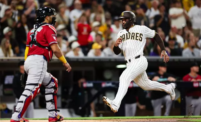 San Diego Padres' Luis Campusano, right, heads home to score on a double hit by Miguel Andujar against the Arizona Diamondbacks in the fourth inning of a baseball game Wednesday, July 8, 2026, in San Diego. (AP Photo/Derrick Tuskan)