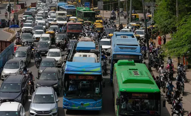 Electric buses move through dense traffic alongside other vehicles and scooters in New Delhi, India, Tuesday, July 14, 2026. (AP Photo/Manish Swarup)