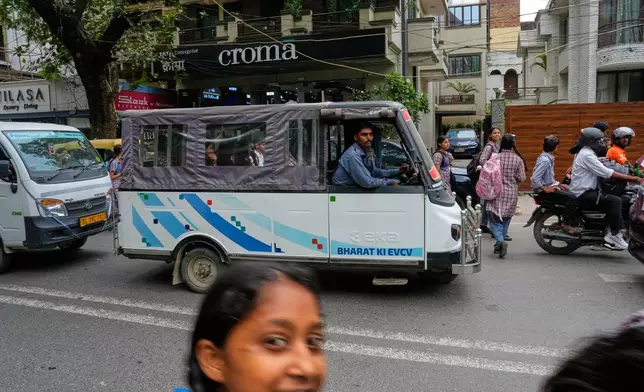 An electric vehicle maneuvers down a road in New Delhi, India, Monday, July 13, 2026. (AP Photo/Manish Swarup)