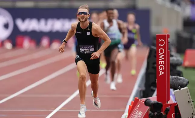 Britain's Josh Kerr wins and breaks a world record in the Men's 1 Mile final during the Novuna London Athletics Meet at the London Stadium, Saturday July 18, 2026. (Adam Davy/PA via AP)
