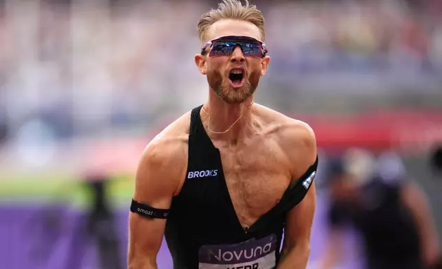 Britain's Josh Kerr celebrates after winning and breaking a world record in the Men's 1 Mile final during the Novuna London Athletics Meet at the London Stadium, Saturday July 18, 2026. (Adam Davy/PA via AP)