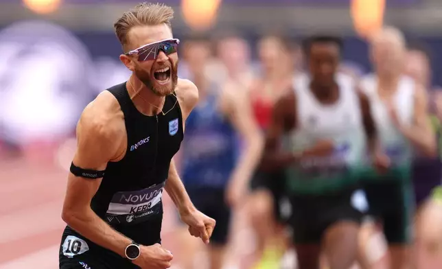 Britain's Josh Kerr celebrates after winning and breaking a world record in the Men's 1 Mile final during the Novuna London Athletics Meet at the London Stadium, Saturday July 18, 2026. (Adam Davy/PA via AP)