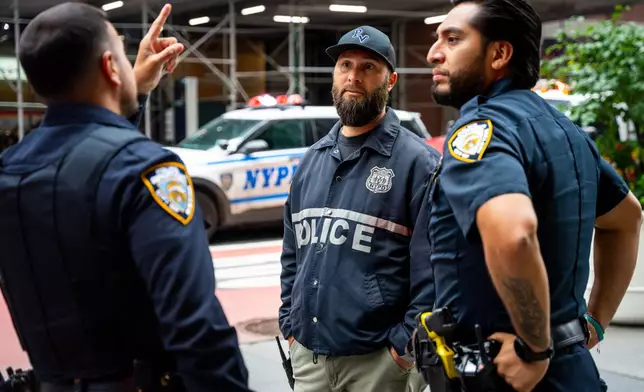 NYPD officers talk about buildings in the area that were evacuated, Tuesday, July 7, 2026, in New York. (AP Photo/Angelina Katsanis)