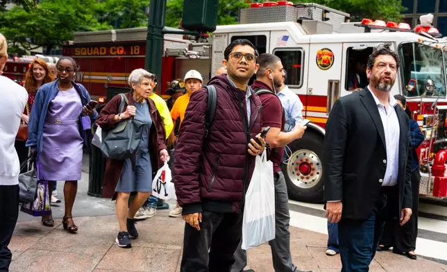 People gather near East 42nd Street after buildings in the area were evacuated, Tuesday, July 7, 2026, in New York. (AP Photo/Angelina Katsanis)