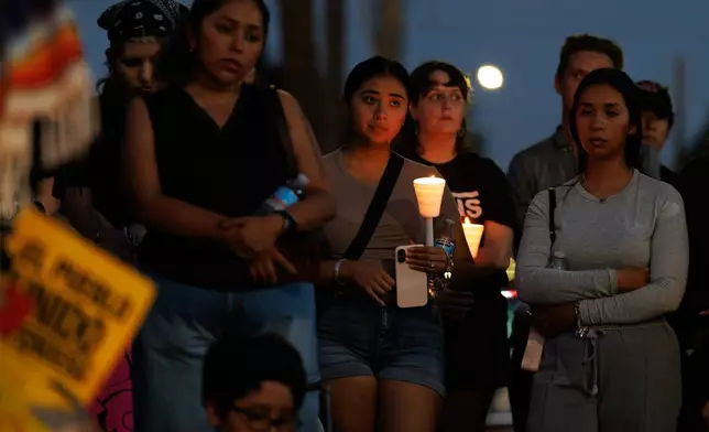 Mourners hold candles during a vigil for Lorenzo Salgado Araujo, a Mexican national fatally shot by a federal immigration agent a day prior, Wednesday, July 8, 2026, in Houston. (AP Photo/Mark Felix)