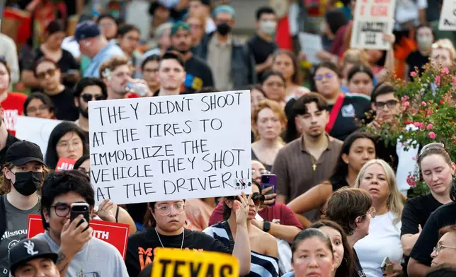 A woman holds up a sign during a vigil for Lorenzo Salgado Araujo, a Mexican national fatally shot by a federal immigration agent a day prior, Wednesday, July 8, 2026, in Houston. (AP Photo/Mark Felix)