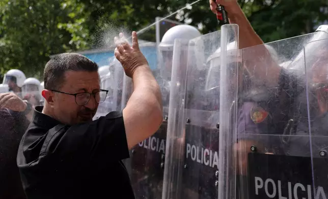 A riot police officer uses pepper spray against a protester during clashes at an anti-government rally in Tirana, Albania, Thursday, July 2, 2026. (AP Photo/Hameraldi Agolli)