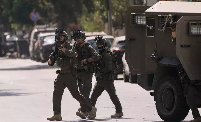 Israeli soldiers move on a street outside the Nablus Speciality Hospital in the West Bank city of Nablus, Friday, July 24, 2026, after Israeli military killed, according to health authorities, at least four Palestinians in the village of Tell in the northern West Bank. (AP Photo/Majdi Mohammed)
