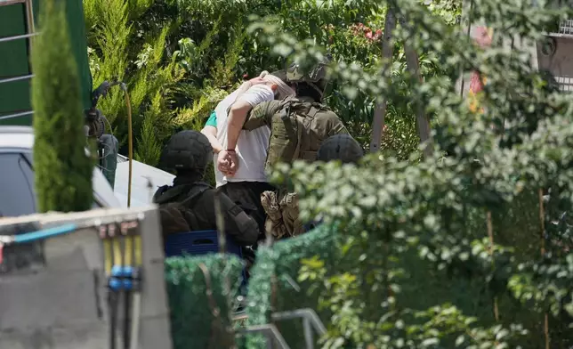 Israeli soldiers arrest a Palestinian man during an army operation in the West Bank village of Tell, near Nablus, Saturday July 25, 2026. (AP Photo/Majdi Mohammed)