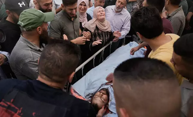People mourn over the body of Jawad Ramadan, who, according to the Palestinian Health Ministry, was killed by Israeli forces near the village of Tell, after his body was brought to Nablus Speciality Hospital in the West Bank city of Nablus, Friday, July 24, 2026. (AP Photo/Majdi Mohammed)