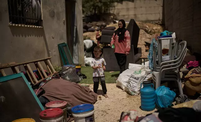 A Palestinian boy stands next to belongings of his family as they repair their house following an attack by Israeli settlers the previous day in the village of Sarra, near the West Bank city of Nablus, Saturday, July 25, 2026. (AP Photo/Leo Correa)