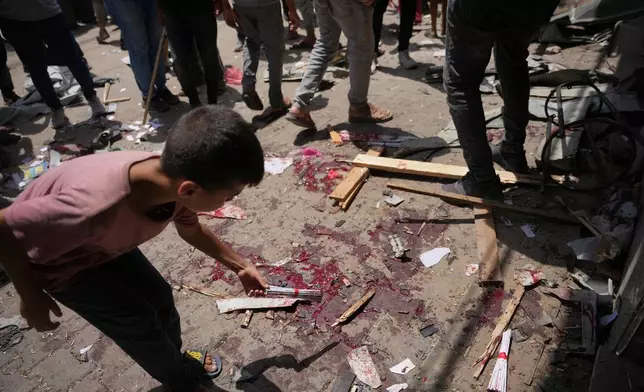 EDS NOTE: GRAPHIC CONTENT - A Palestinian child inspects the site of an Israeli military strike, in Deir al-Balah, central Gaza Strip, Saturday, July 25, 2026. (AP Photo/Abdel Kareem Hana)